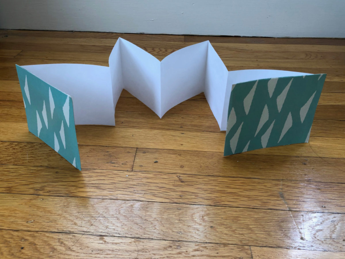 Detailed step for making a folded paper book.