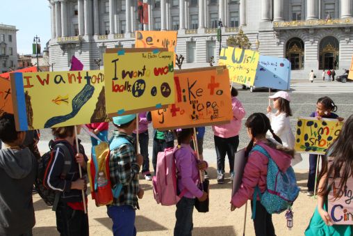 Children holding posters outside San Francisco City Hall.