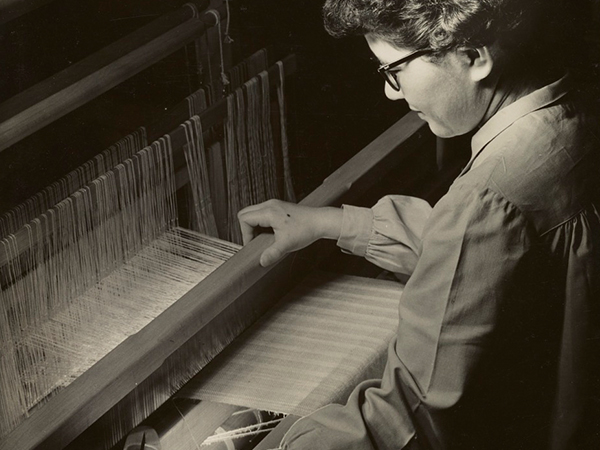 A woman sitting at a loom.