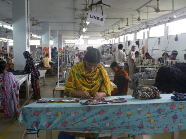 https://education.asianart.org/wp-content/uploads/sites/6/2021/12/Garment_factory_in_Bangladesh_Women_working-600x450.jpeg 1x, https://education.asianart.org/wp-content/uploads/sites/6/2021/12/Garment_factory_in_Bangladesh_Women_working-1200x900.jpeg 2x